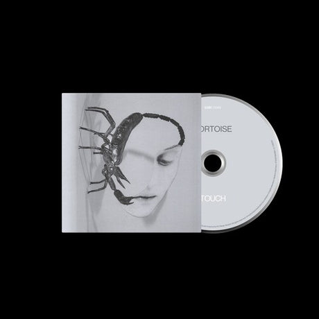 Tortoise "Touch" CD with cover featuring a face and scorpion illustration on a white background, shown with a light grey colored CD