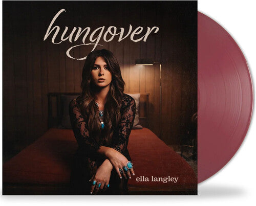 Vinyl album cover for Ella Langley's 'Hungover' featuring Ella sitting on a bed with beige cursive 'hungover' text above her and with plum colored vinyl record sticking out the side of the sleeve.