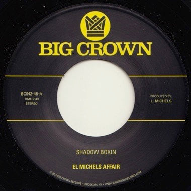 El Michels Affair "Shadow Boxin" 7 inch record label set on a black 7 inch vinyl record