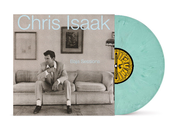 Vinyl record with cover featuring Chris Isaak sitting on a couch, titled 'Baja Sessions' by Chris Isaak. Shown with a sea green/blue colored vinyl record