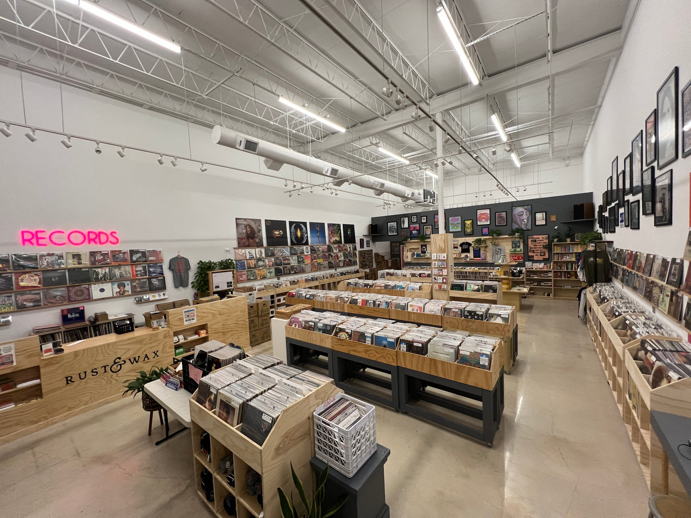 Overhead photo of Rust & Wax retail floor, depicting wooden counter, Pink record sign, individual records on the walls, and several wooden bins filled with records.
