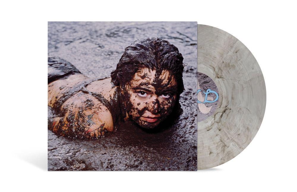 Album cover showing Remi Wolf laying in mud, covered in mud, and looking forward. Smoke colored vinyl sticking out of the right side of the vinyl record sleeve.