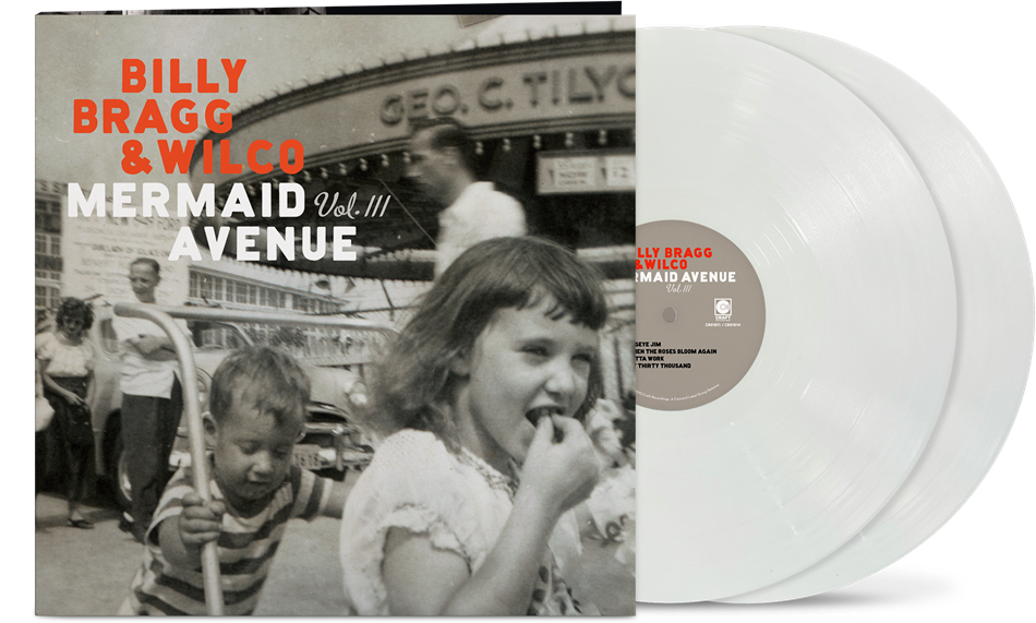 Vinyl album cover showing a child pushing another child on a hand cart in front of 3 other people and a large building (all in black & white) with orange text "Billy Bragg & Wilco" and white text "mermaid avenue vol. iii" with two white vinyl records sticking out the side of the sleeve.