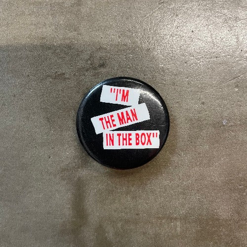 Alice in Chains "I'm The Man In The Box" red text on white bars set against black backdrop