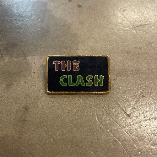 The Clash Enamel Pin - Front image red and green text against black backdrop