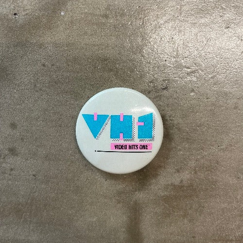 VH1 Pin Pink and blue text on white backdrop