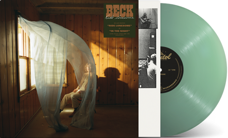 Image of Beck sitting on a chair in a room with wood paneling walls and an open window with curtains blowing inward. Beck Ride Lonesome sticker on top right corner of room. Vintage green vinyl record peeking out of the side of the sleeve.
