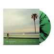 The Menzingers "Everything I Ever Saw" album cover with a palm tree and beach scene on the cover. Shown with a green and black splatter vinyl record