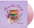 Vinyl record with cover featuring a person sitting by a window overlooking a lavender field and sunset, with 'Lavender Days' and 'Caamp' text. Shown with a pink vinyl record