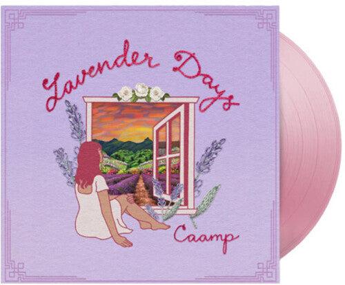 Vinyl record with cover featuring a person sitting by a window overlooking a lavender field and sunset, with 'Lavender Days' and 'Caamp' text. Shown with a pink vinyl record