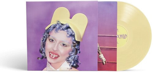 Ashnikko "Smoochies" album cover which has a purple and yellow cover featuring Ashnikko with blue hair and a yellow hat. Shown with a butter yellow colored vinyl record.