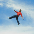 Alex Warren - Wildchild album cover, featuring Warren suspended in a cloudy blue sky