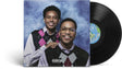 A vinyl record album shown with its front cover and a black record partially visible. The cover features Cordae and Anderson. Paak in argyle vests against a blue marbled backdrop, with a Parental Advisory label at the bottom.