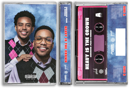 A cassette tape case shown with its front cover and pink cassette tape partially visible. The cover features Cordae and Anderson. Paak in argyle vests against a blue marbled backdrop, with a Parental Advisory label at the bottom. Text on the spine of the cassette case and on the pink cassette reads 'Heavy Is The Crown'
