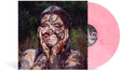 A vinyl record partially pulled from its sleeve, showing a pink translucent record and the cover art of Remi Wolf smiling and covered in mud against a dark outdoor background.