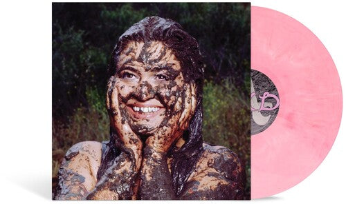 A vinyl record partially pulled from its sleeve, showing a pink translucent record and the cover art of Remi Wolf smiling and covered in mud against a dark outdoor background.