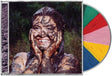 Compact disc jewel case showing Remi Wolf covered in mud and smiling with nature backdrop and a beach ball looking CD sticking out of the side of the case.