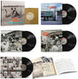 Box set for Billy Bragg & Wilco Mermaid Avenue featuring the slip case, 7" record, 4 separate LP records, and an open booklet against a white backdrop