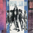 Album cover for Pearl Jam Ten Live featuring the band in a circle with their arms raised set against a multi colored (red, blue, white) backdrop and "Pearl Jam Live" text at the top in light blue coloring.