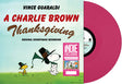 Album cover for 'A Charlie Brown Thanksgiving' with Snoopy and Woodstock, featuring Vince Guaraldi's music. Shown with a pink vinyl record.