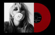 A vinyl record partially pulled from its sleeve, shown against a black background. The sleeve features a black-and-white portrait of Miley holding a white rose in her lips, while the record itself is a vivid red with a black center label.