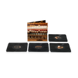 Four black vinyl records, arranged in a row with record sleeve behind them featuring the inner workings of a piano.