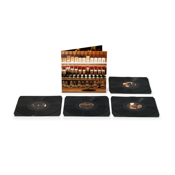 Four black vinyl records, arranged in a row with record sleeve behind them featuring the inner workings of a piano.