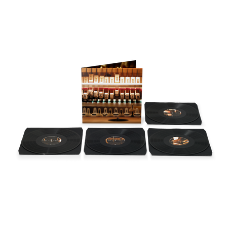 Four black vinyl records, arranged in a row with record sleeve behind them featuring the inner workings of a piano.