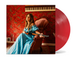Image of Margo Price in Blue Dress sitting in a red chair holding a shotgun while in a room with red wallpaper and piano keys on the wall, plus red vinyl record peeking out of the side of the record sleeve.