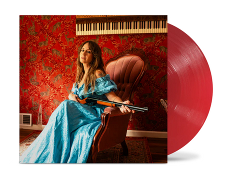 Image of Margo Price in Blue Dress sitting in a red chair holding a shotgun while in a room with red wallpaper and piano keys on the wall, plus red vinyl record peeking out of the side of the record sleeve.