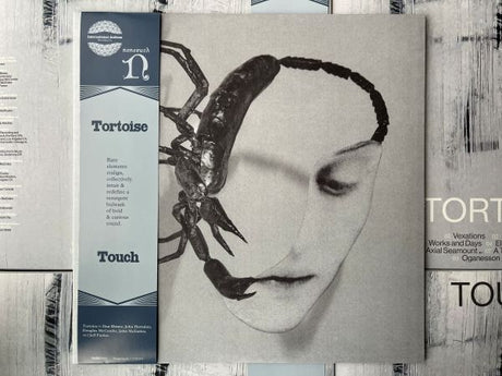 Tortoise "Touch" album cover featuring a face with a scorpion on it, with an OBI strip on the left side