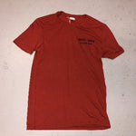 Rust & Wax Record Shop logo in black ink on the front pocket area of a red t-shirt