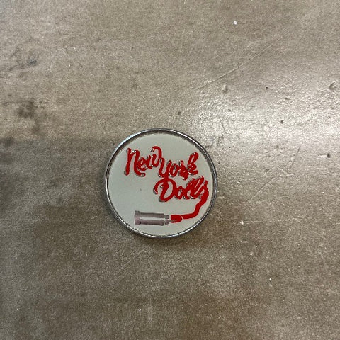 New York Dolls Enamel pin - red text drawn by lipstick cannister against white backdrop