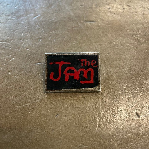 The Jam Enamel Pin - Front image red text against black backdrop