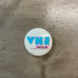 VH1 Pin Pink and blue text on white backdrop